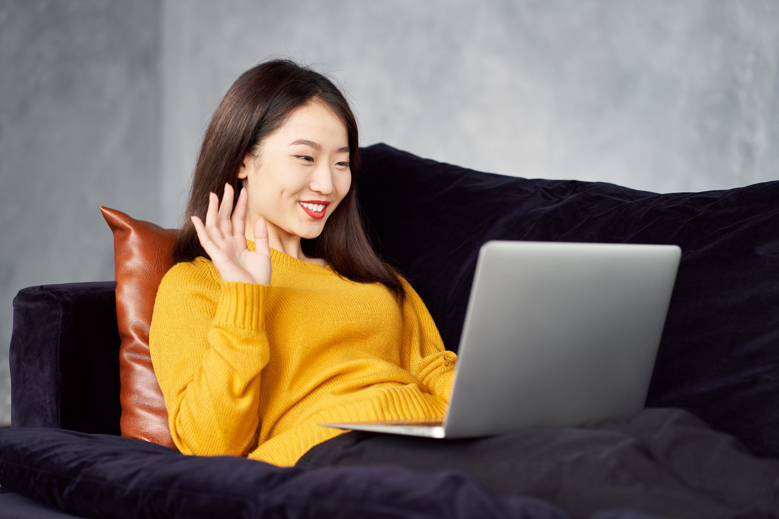 asian-woman-waving-hands-looking-to-laptop-online--ZGZ6DXW-min