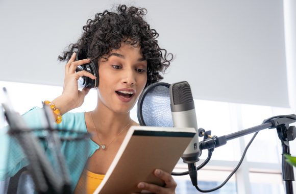 Mulher gravando Podcast com headphone e microfone profissional